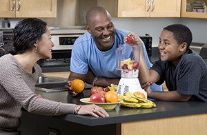 Une famille prépare des boissons fouettées aux fruits.